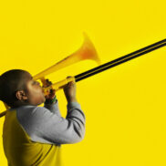 Jongen speelt op PBone, een plastic trombone